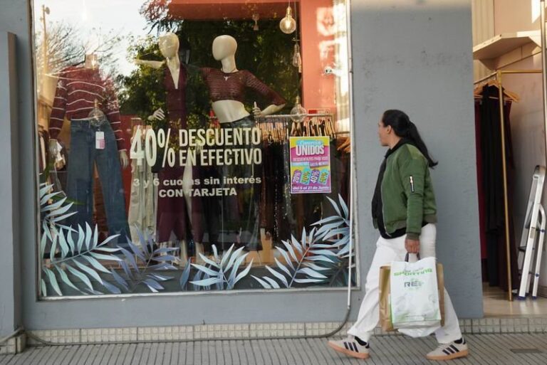 Vidrieras de comercios en el microcentro de Corrientes con carteles de promociones