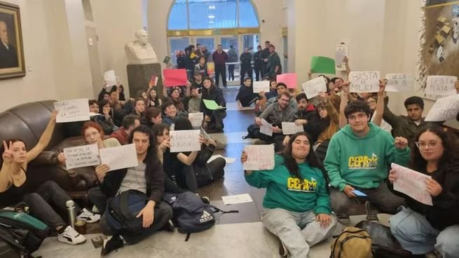 Estudiantes universitarios sentados en el piso del Palacio Pizzurno durante una protesta por la ley de Financiamiento Universitario