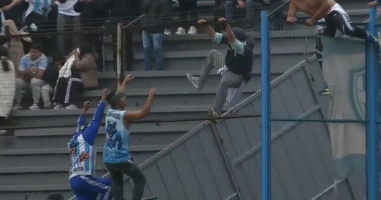 Hinchas de Gimnasia y Tiro de Salta y Gimnasia de Jujuy peleando trepados al alambrado durante el partido