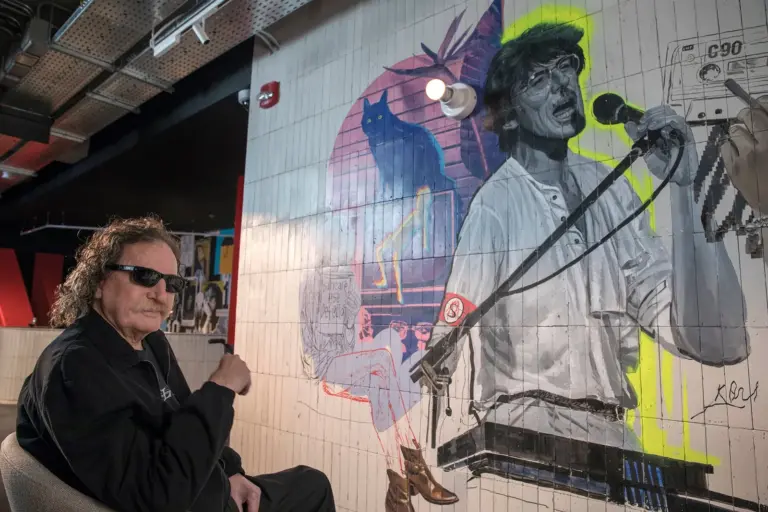 Charly García en el balcón de su casa saludando a sus seguidores