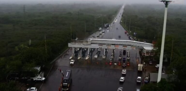 Automovilistas esperan bajo la lluvia para tramitar la oblea del telepeaje en el peaje del puente General Belgrano, entre Corrientes y Chaco.
